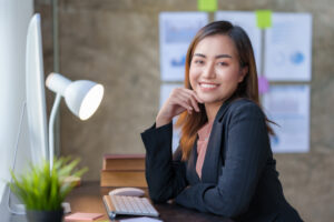 A young professional in an office setting, working on a neatly arranged desk.