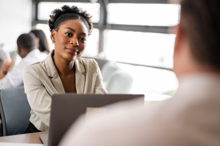 A young professional listening intently to another person in front of her