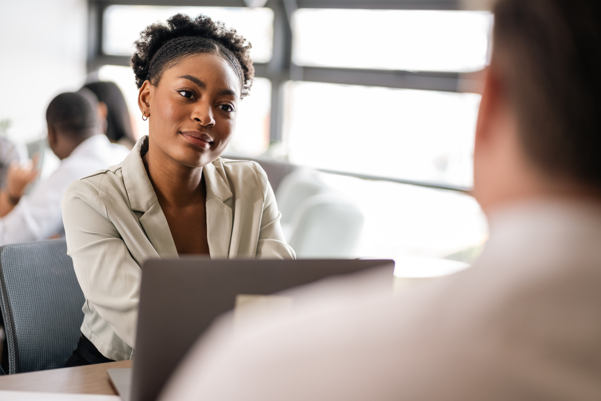 A young professional listening intently to another person in front of her